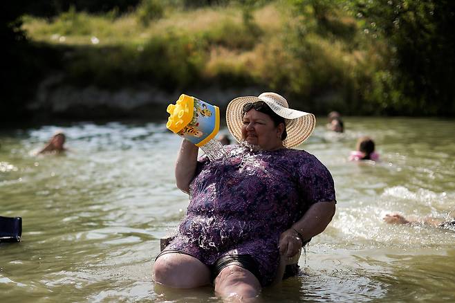 6월 25일 코소보 그자코바 인근 에레닉 강에서 한 여성이 강물로 더위를 식히고 있다./로이터 연합뉴스