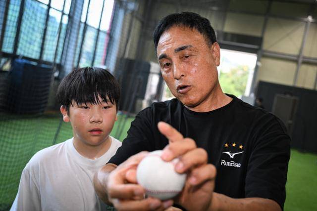 후진 양성에 힘쓰는 송진우가 야구 꿈나무에게 투구 그립을 알려주고 있다. 청주=남동균 인턴기자