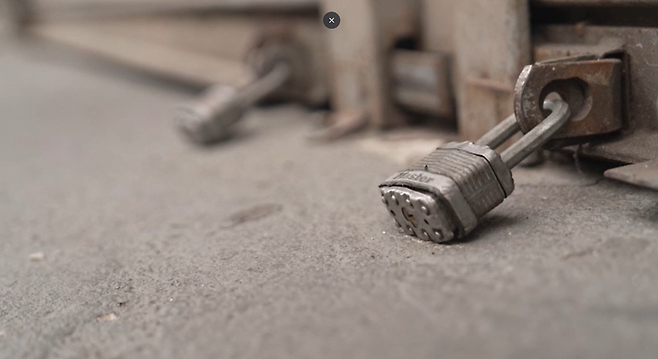 상점에 셔터가 내려져 있고, 자물쇠로 잠겨 있다.(로스앤젤레스 패션 거리)