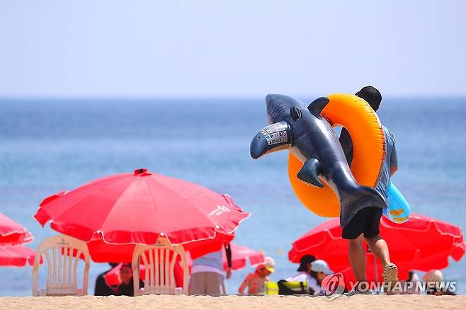 여름 피서철 본격 시작 (속초=연합뉴스) 류호준 기자 = 5일 강원 속초 해수욕장에서 한 피서객이 튜브를 들고 해변으로 가고 있다. 2025.7.5 ryu@yna.co.kr