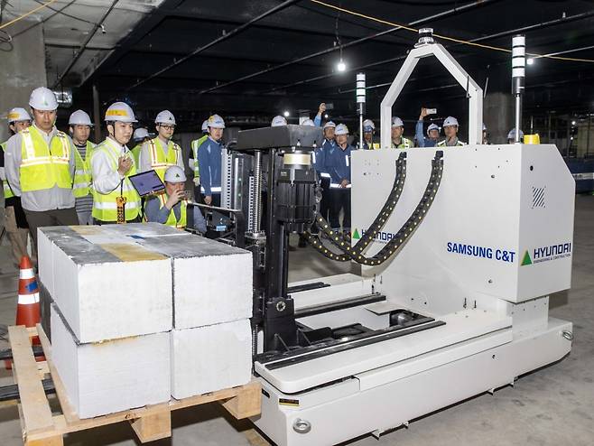 삼성물산 건설부문과 현대건설 관계자들이 지난 3일 인천 청라 하나드림타운에서 '스마트 자재 운반 로봇' 기술 시연회를 참관하고 있다. 삼성물산, 현대건설 제공