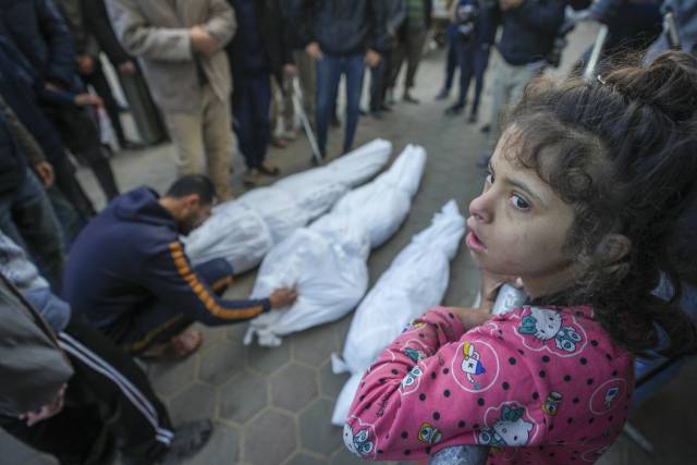 ▲ⓒA girl watches as Mohammad Eid mourns his daughter Dima, along with her uncle and grandfather, who were killed in an Israeli airstrike on Saturday, during their funeral in Deir al-Balah, central Gaza Strip, Sunday, Jan. 12, 2025.ⓒ AP Photo/Abdel Kareem Hana