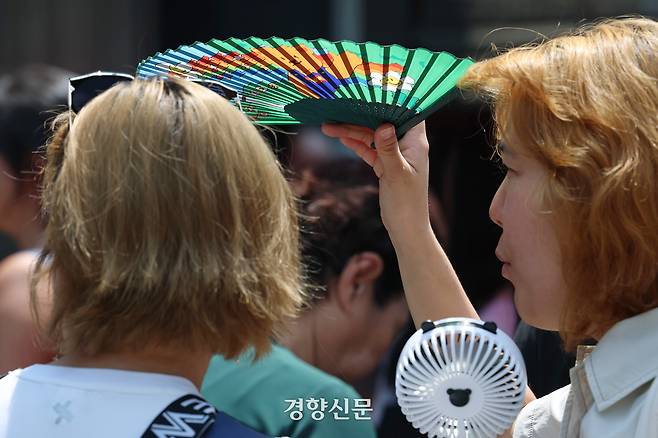 전국적으로 무더운 날씨를 보인 지난달 23일 서울 중구 남대문시장을 찾은 시민이 부채로 햇볕을 가리고 있다. 정효진 기자