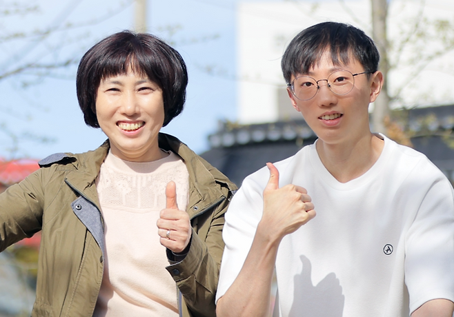 10번이 넘는 두경부암 수술을 이겨내고 턱걸이 챔피언이라는 타이틀을 얻게 된 김동호 군(오른쪽)과 동호 군의 어머니