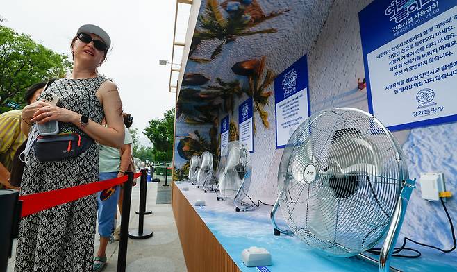 절기 상 소서(小暑)로 본격적인 더위가 시작된 7일 서울 종로구 광화문광장에서 외국인 관광객과 시민들이 여름상상 놀이터의 선풍기 바람을 쐬고 있다.