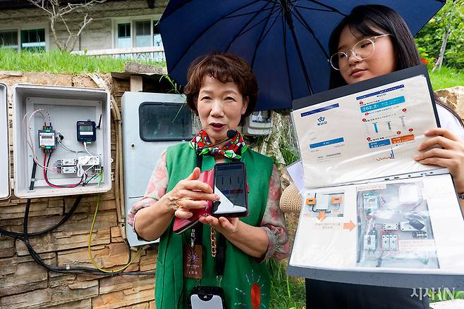 6월24일 오후 사회적협동조합 ‘해유’의 여성 에너지 활동가 ‘솔라시스터즈’ 송정희씨가 방문객들에게 미호동 에너지 전환 마을을 소개하며 ‘위너지 앱’을 보여주고 있다. ⓒ시사IN 신선영