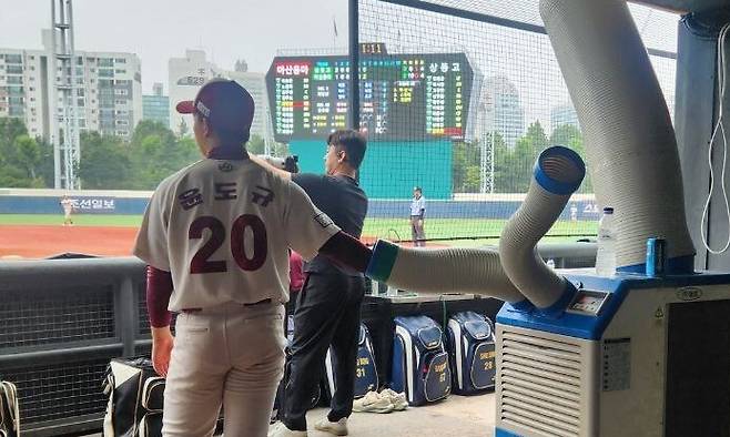 지난 7일 서울 양천구 목동야구장에서 열린 제80회 청룡기 전국고교야구선수권대회 겸 주말리그 왕중왕전 경기 중 한 선수가 이동식 에어컨 앞에서 더위를 식히고 있다. 장종우 기자