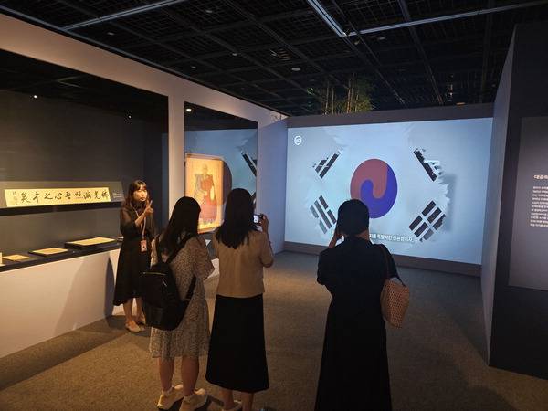 부산박물관의 특별전 ‘광복의 시간, 그날을 걷다:부산의 독립운동과 범어사’에서 관람객이 용성 대종사 진영과 3·1운동 당시 태극기 등을 담은 영상을 살펴보고 있다. 조봉권 선임기자