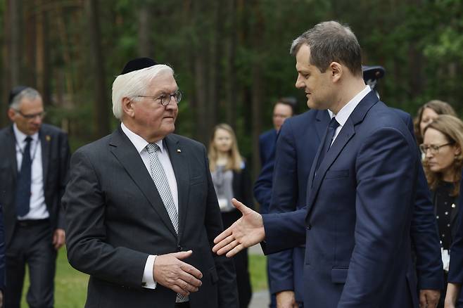 7일(현지시간) 리투아니아 수도 빌뉴스 외곽의 파네리아이 숲에서 유대인 남성의 전통 모자 ‘키파’를 머리에 쓴 프랑크 발터 슈타인마이어 독일 대통령(왼쪽)이 긴타우타스 팔루츠카스 리투아니아 총리에게 악수를 청하고 있다. 파네리아이 숲은 2차대전 당시 유대인을 비롯해 약 12만명의 민간인이 나치 독일에 의해 처형을 당한 곳이다. AP연합뉴스