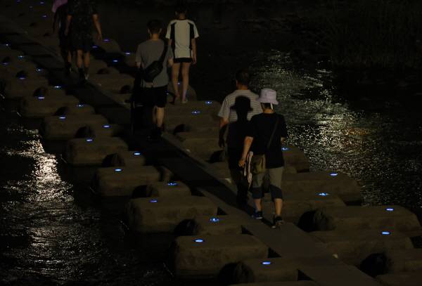 열대야가 이어진 7일 대구 신천에서 시민들이 산책하며 더위를 나고 있다.연합