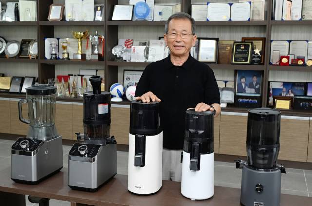 8일 김해 휴롬 공장에서 ‘글로벌 착즙기 1위’ 휴롬을 창업한 김영기 회장이 신제품 앞에서 포즈를 취하고 있다./전강용 기자/