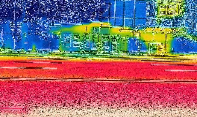 연일 폭염특보가 이어지고 있는 10일 오전 광주 서구 한 버스정류장을 열화상 카메라로 촬영한 모습. 온도가 낮은 곳은 푸르게, 높은 곳은 붉게 표시돼 있다. 연합뉴스