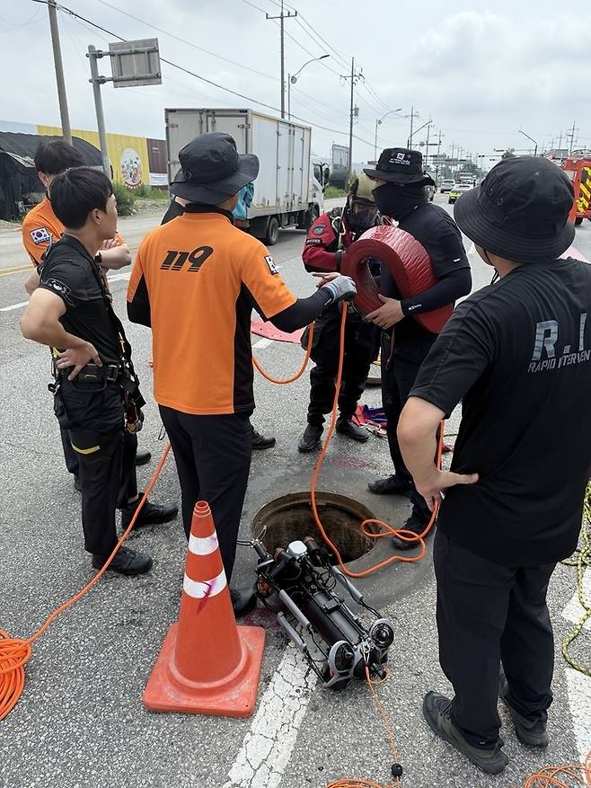 지난 6일 소방대원들이 맨홀 실종자를 찾기 위해 수색장비를 맨홀로 들여보내고 있다. 인천시 소방본부 제공