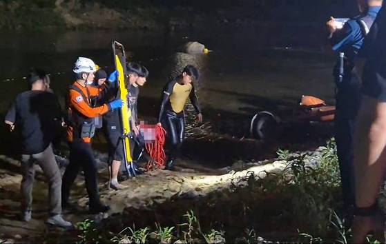 지난 9일 오후 물놀이를 하다 20대 4명이 숨진 충남 금산군 제원면 기러기공원에서 소방대원이 시신을 인양하고 있다. [사진 충남소방본부