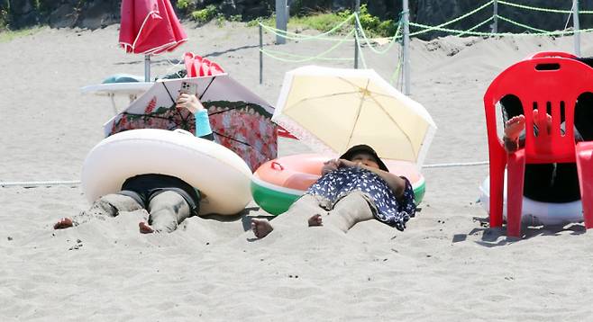 "이열치열 더울땐 모래찜질". 폭염이 이어지는 지난 3일 제주시 삼양해수욕장에서 피서객들이 모래 찜질을 하며 무더위를 쫓고 있다. /사진=뉴스1