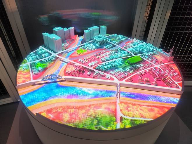 10일(현지 시간) 일본 오사카 유메시마 인공섬에서 개최된 오사카 엑스포 내 네이버클라우드 부스 내 디지털트윈을 활용한 홍수 조감도. 빨간 부분이 홍수로 피해를 볼 것으로 예상되는 지역이다. 고재우 기자