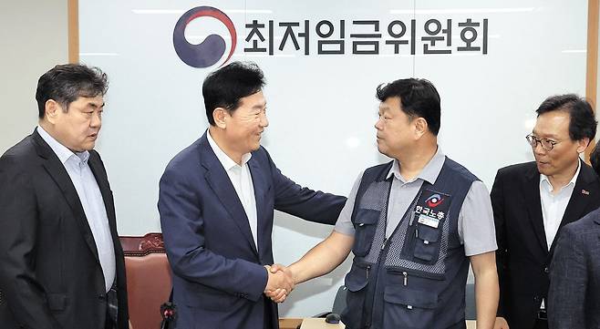 내년도 최저임금이 전년 대비 2.9% 오른 1만320원(시간당)으로 결정됐다. 사진은 지난 10일 늦은 밤 최저임금위원회를 마친 뒤 류기정 사용자위원(경총 전무)과 류기섭 근로자위원(한노총 사무총장)이 악수하는 모습. 왼쪽부터 이인재 최저임금위원장, 류기정·류기섭 위원, 이명로 중기중앙회 인력정책본부장. /연합뉴스