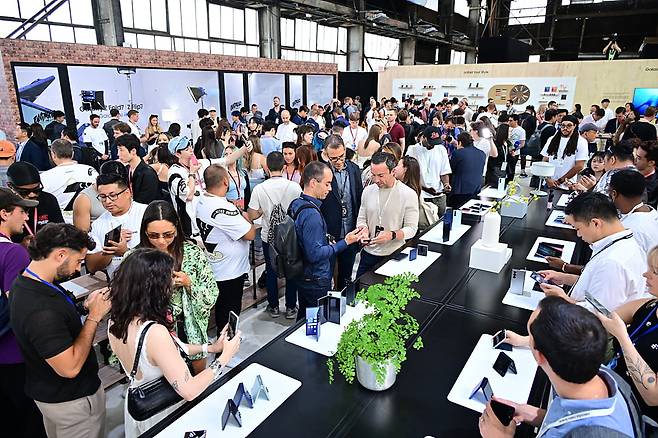 지난 9일(현지시간) 미국 뉴욕 브루클린 듀갈 그린하우스에서 열린 '갤럭시 언팩 2025' 행사장 내 체험공간에서 관람객들이 갤럭시Z폴드·플립7을 살펴보고 있다. 사진=삼성전자