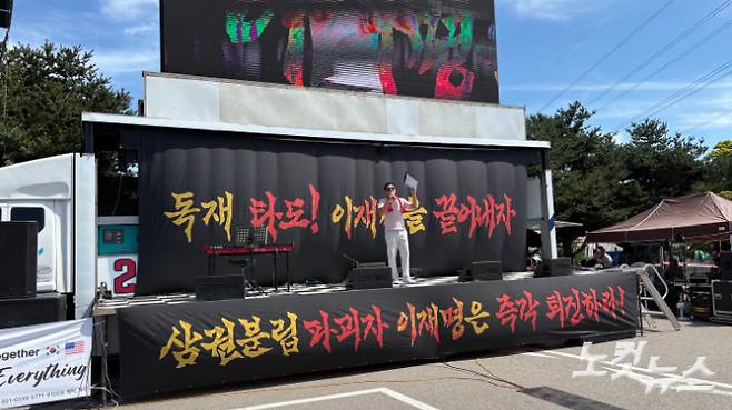 12일 오후 3시 경기 의왕시 서울구치소 민원실 맞은편 주차장에서 열린 집회에서 윤 전 대통령 지지자가 무대에 올라 발언하고 있다.