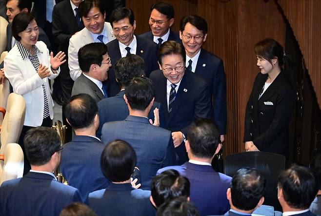 이재명 대통령이 지난달 26일 국회 본회의장에서 2025년도 제2회 추가경정예산안 시정연설을 마친 뒤 퇴장하며 더불어민주당 의원들과 인사하고 있다. ⓒ국회사진기자단