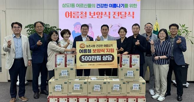 “이웃의 여름,, 함께 지켜요.” 농협 제주본부와 삼도1동이 초복을 맞아 마련한 ‘여름철 보양식 전달식’에서 관계자들이 나눔의 의미를 함께하면서 기념 촬영을 하고 있다. 500만 원 상당의 삼계탕 250세트를 지역 어르신들에게 전달했다. (제주농협 제공)