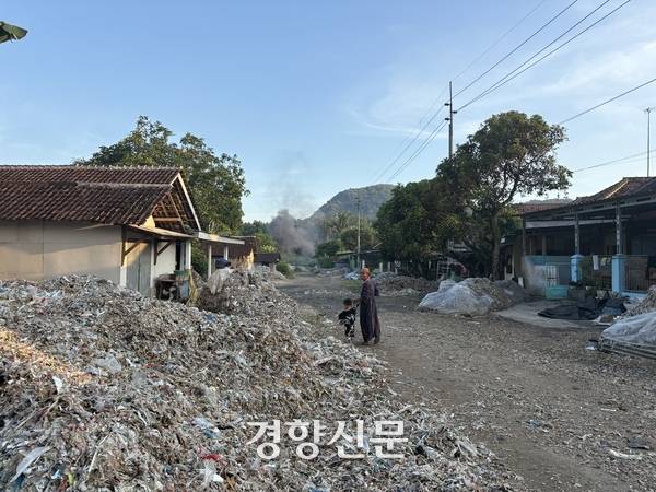 지난 4월25일(현지시간) 인도네시아 자와티무르 말랑의 감핑안 마을에서 한 여성이 아이와 함께 집 앞을 걷고 있다. 오경민 기자