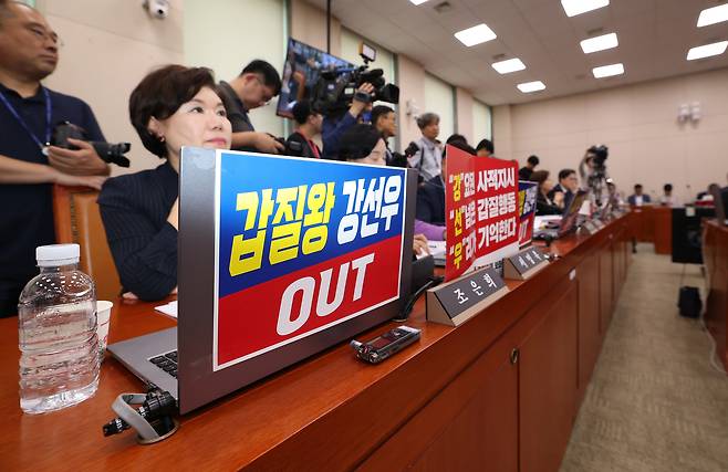 국민의힘 소속 국회 여성가족위원회 위원들이 14일 강선우 여성가족부 장관 후보자 인사청문회에서 강 후보자를 비판하는 손팻말을 노트북에 붙이고 있다. 권도현 기자
