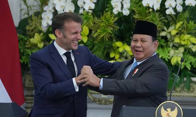 지난 5월 인도네시아 자카르타를 방문한 에마뉘엘 마크롱 프랑스 대통령(왼쪽)이 활짝 웃으며 프라보워 수비안토 대통령과 인사를 나누고 있다. AP연합뉴스