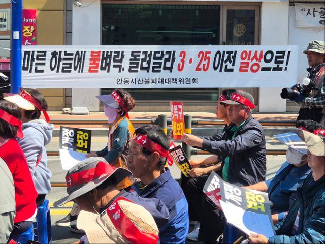 4월 29일 안동시 명륜동 안동시청 앞에서 경북 산불 이재민들이 피해 보상을 촉구하는 집회를 열고 있다. 건너편 거리에 걸린 현수막에 '마른 하늘에 불벼락, 돌려달라 3·25 이전 일상으로!'라는 문구가 적혀 있다. 안동=김나연 기자