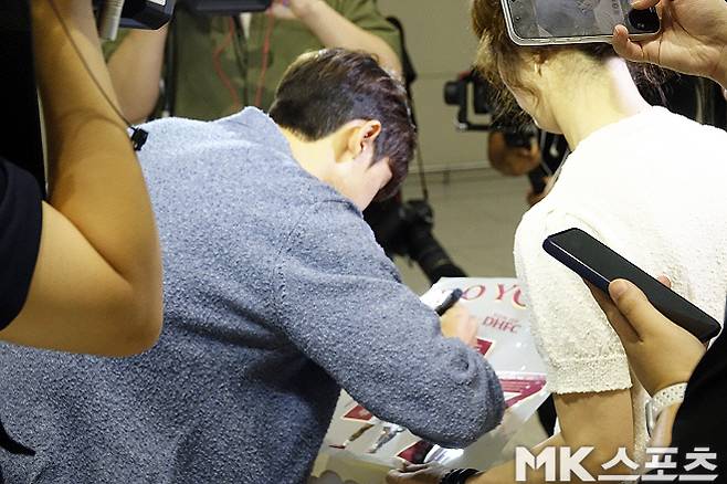 이날 인천공항을 찾은 팬들에게 사인해 주고 있는 윤도영. 사진=이근승 기자
