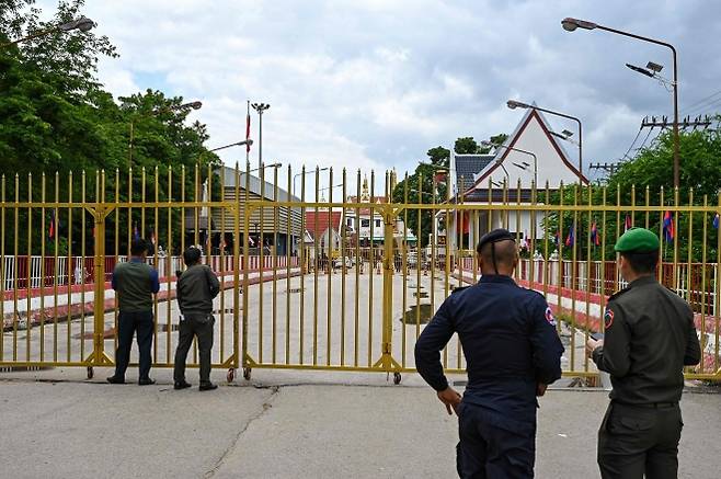 캄보디아 경찰 관계자들이 캄보디아-태국 포아펫 국제 국경 검문소 문 옆에 서 있다. 2025.6.24 AFP 연합뉴스