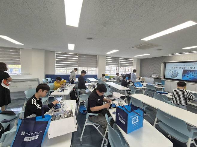 한내초 학생들이 'AI 스튜디오'에서 피지컬 컴퓨팅 교구로 로봇축구용 로봇을 만들고 있다.