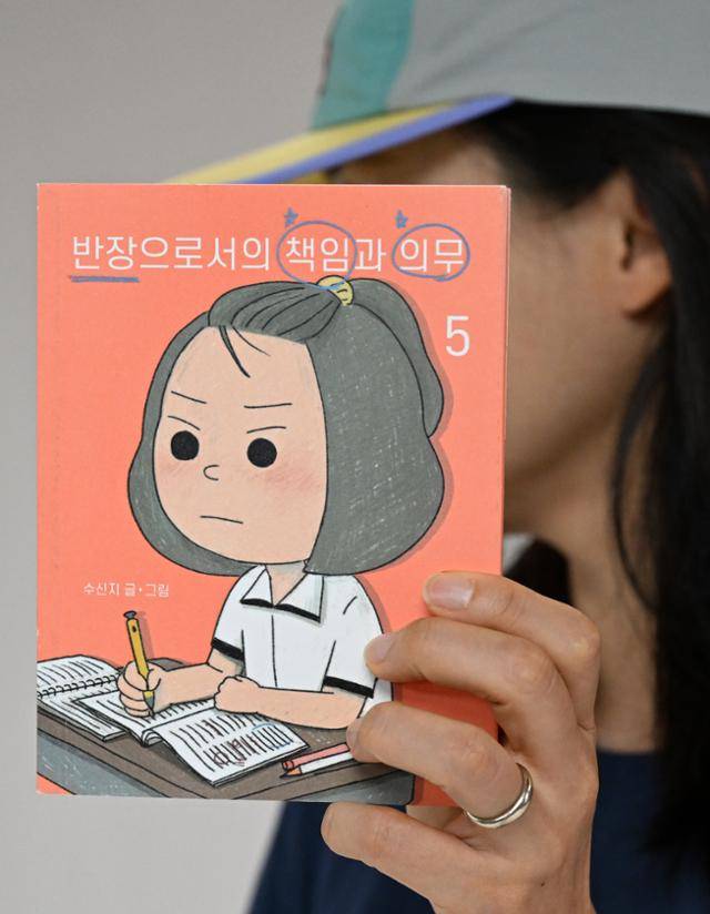 인기 웹툰 '며느라기' 등을 쓰고 그린 수신지 작가가 최근 펴낸 만화책 '반장으로서의 책임과 의무' 5권을 들어 보이고 있다. 서재훈 기자