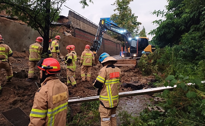 ▲ 경기도 대부분 지역에 호우주의보가 내려진 16일 오후 오산시 가장교차로 고가도로 옹벽이 무너져 소방관들이 매몰된 차량에 대해 구조 작업을 펼치고 있다. /사진제공=경기도소방재난본부