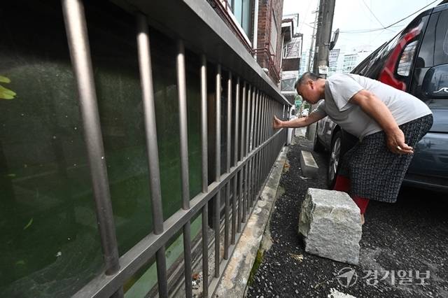 경기지역에 집중 호우가 쏟아진 16일 도내 한 반지하 주택 주민이 불안한 모습으로 창살을 살펴보고 있다. 조주현기자