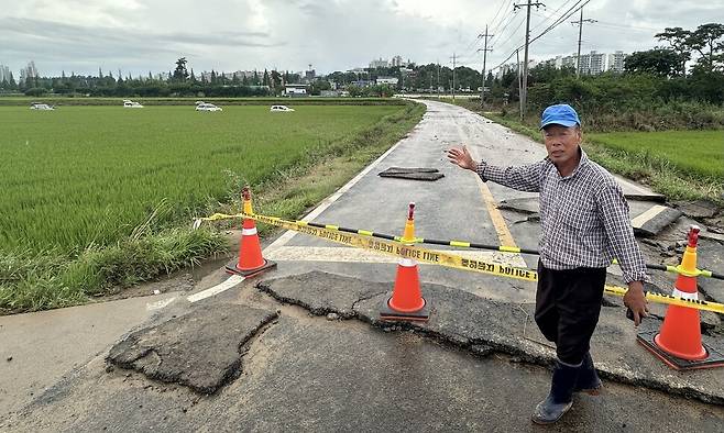 논 주인 임태래씨가 농로에서 차량들이 침수돼 떠다니게 된 정황을 설명하고 있다. 임씨는 범람한 하천물이 화살표 방향으로 농로를 덮쳐 지나던 차량들이 침수했다고 말했다. 송인걸 기자