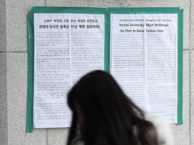 A student walks past protest posters at Yonsei University in Seoul urging the school administration to cancel its planned tuition increase in this photo taken on Jan. 20, 2025. Despite student opposition, the university approved its first undergraduate tuition hike in 15 years just four days later, raising fees by 4.98 percent. (Citizens' Alliance for Free and Standardized University Education)