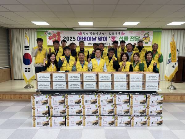 어버이날 맞이 효 선물 전달 행사에서 주민들과 함께 기념촬영하는 조익현 선남면장.