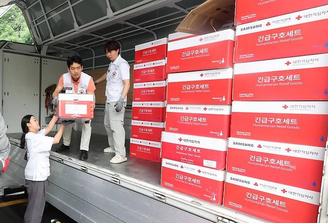 18일 인천 연수구 대한적십자사 인천지사에서 적십자 직원들이 충남 지역 수해민에게 전달될 긴급 구호키트 물자를 옮기고 있다. 인천=뉴시스