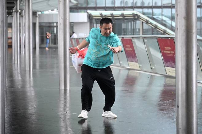 20일(현지시간) 홍콩 센트럴 지역에서 한 남성이 태풍 ‘위파’의 강풍에 몸을 가누며 버티고 있다. 이날 위파는 홍콩에서 60km 이내까지 접근했으며, 홍콩 당국은 태풍 경보 최고 단계인 10호를 발령했다.(사진=AFP)