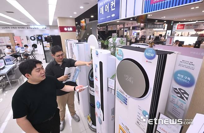 역대급 무더위가 계속되고, 1등급 전자제품 대상 환급제도를 이용하는 고객이 증가하면서 냉방제품 수요가 증가했다. 가전양판점에서는 7월 초중순 냉방제품 판매량이 지난해 대비 에어컨은 2~3배 이상, 선풍기는 1.5배 이상 상승한 것으로 나타났다. 주말 서울 용산 전자랜드에서 고객이 에어컨을 살펴보고 있다. 박지호기자 jihopress@etnews.com
