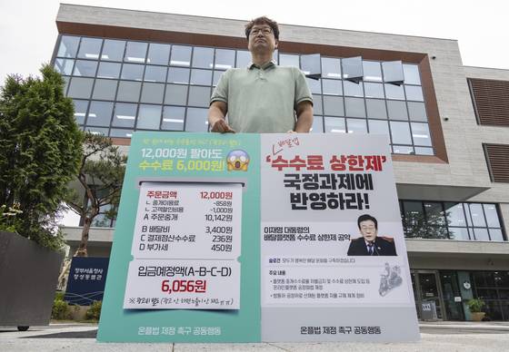지난 6월 25일 서울 종로구 국정기획위원회가 입주한 정부서울청사 창성동 별관 앞에서 온플법 제정 촉구 공동행동 관계자들이 배달앱 총수수료 상한제 국정과제 반영을 촉구하며 1인 시위를 벌이고 있다. 연합뉴스