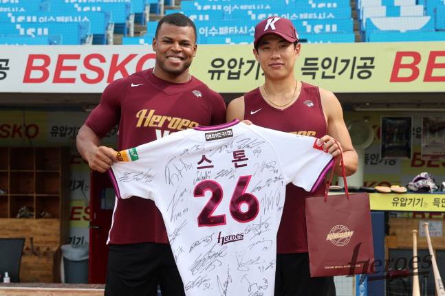 키움 스톤(왼쪽)이 20일 삼성전을 앞두고 동료들이 준비한 사인 유니폼을 들고 주장 송성문과 기념 촬영을 하고 있다. /사진=키움 히어로즈 제공