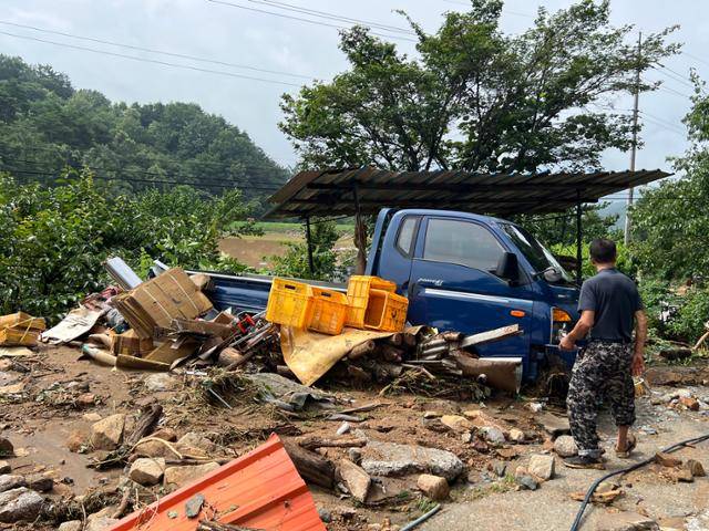 20일 경남 산청군 산청읍 부리마을 주민 조창석씨가 산사태로 밀려온 흙에 잠긴 자신의 화물차를 바라보고 있다. 산청=권정현 기자