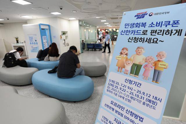 이재명 정부의 첫 대규모 경기 부양책인 '민생회복 소비쿠폰' 신청이 시작된 21일 서울 시내 한 은행에 관련 배너가 설치돼 있다. 연합뉴스
