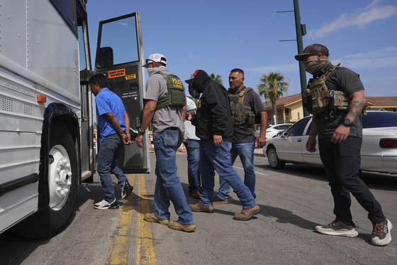 지난 17일(현지시간) 미국 샌안토니오에서 연방요원들이 이민법원에 출두한 뒤 구금 결정이 내려진 한 남성을 교통 버스까지 호위하고 있다. AP=연합뉴스