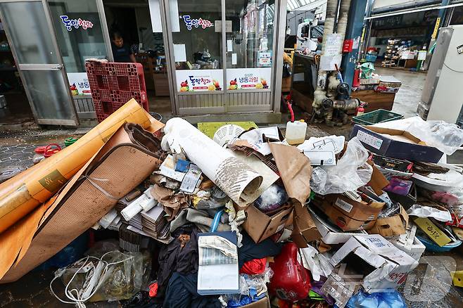 충청권을 중심으로 호우특보가 내려진 17일 충남 당진시 읍내동 당진전통시장에서 침수 피해를 본 상인들이 물품 등을 정리하고 있다. 2025.7.17/뉴스1 ⓒ News1 김도우 기자