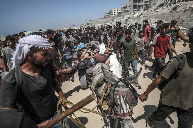 20일(현지시간), 가자지구 북부 지킴(Zikim) 인근 구호물자 배급 지점에서 총에 맞아 숨진 팔레스타인인들의 시신이 당나귀 수레에 실려 옮겨지고 있다. EPA연합뉴스