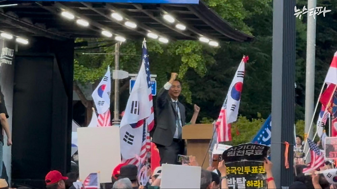 15일 서울대 정문 앞에서 열린 집회 현장에서 환호하는 지지자들에게 주먹을 흔들며 화답하는 모스탄의 모습.