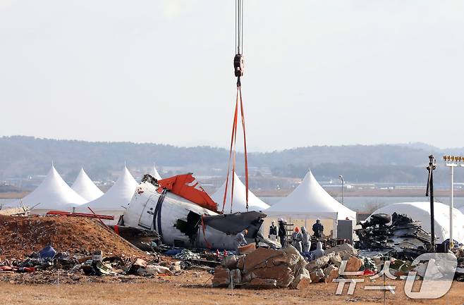 15일 오전 전남 무안국제공항 참사 현장에서 항공·철도사고 조사위원회 관계자들이 기체 잔해 수습을 위해 기중기에 걸고 있다. 2025.1.15/뉴스1 ⓒ News1 박지현 기자